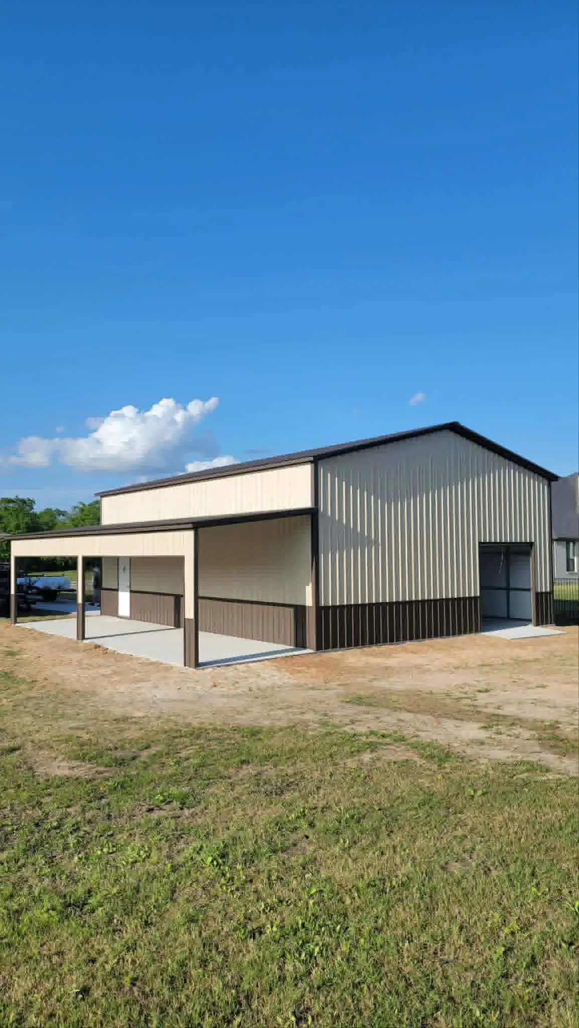 Tan metal building with an attached side carport