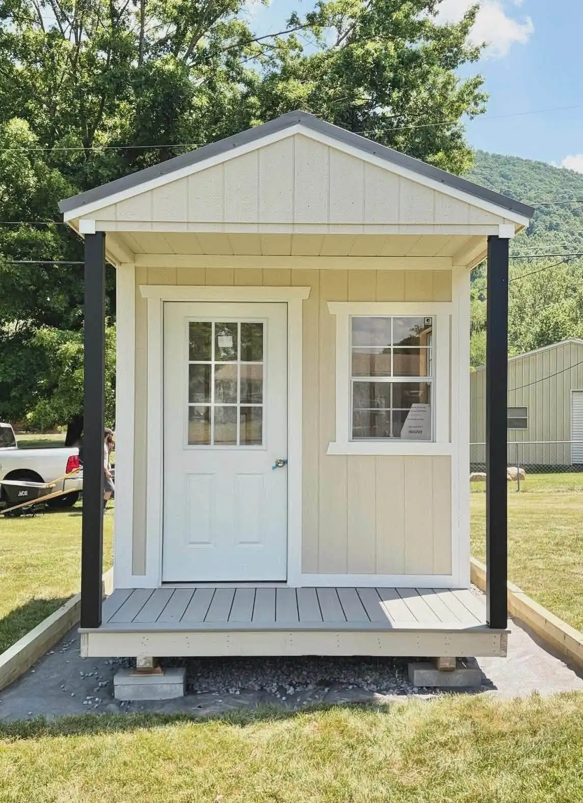 Cream portable building with a front porch and a white door