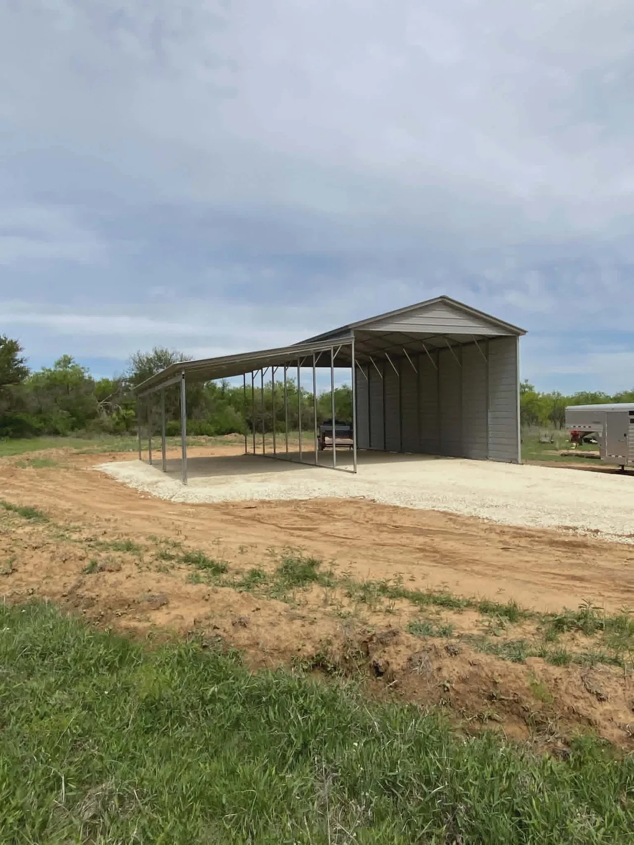Open metal carport on a gravel pad