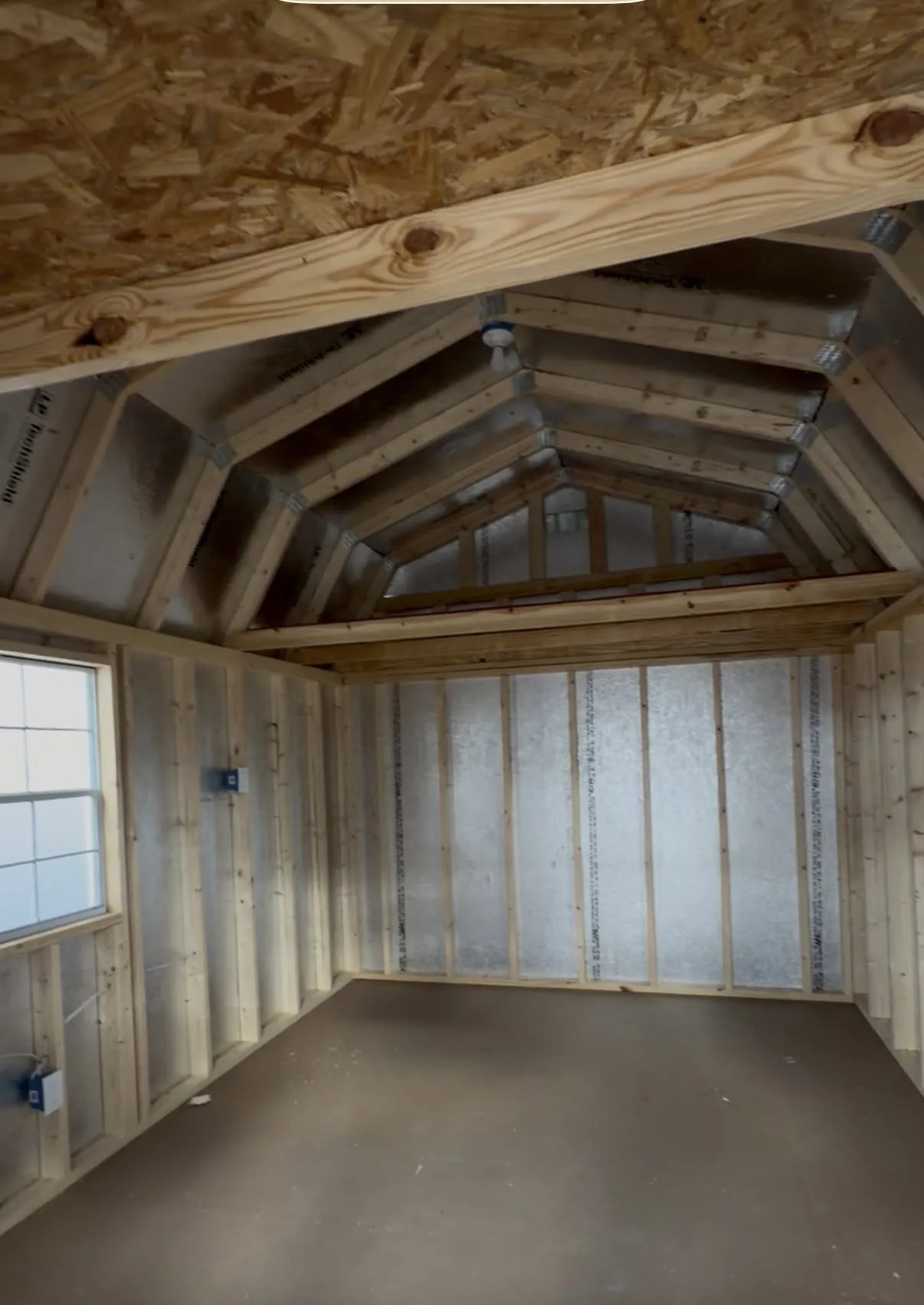 Inside a lofted portable building with framed walls and loft framing