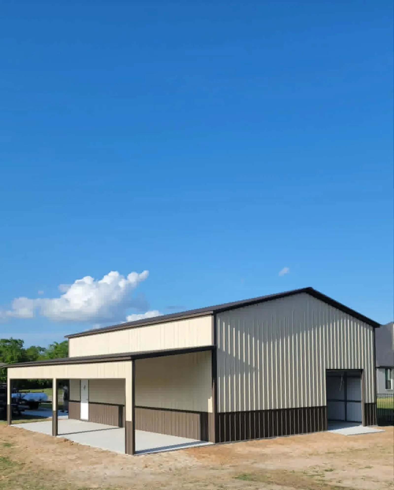 Tan metal building with an attached side carport